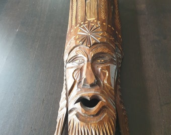 Large woodcarved masked man with feathers handmade