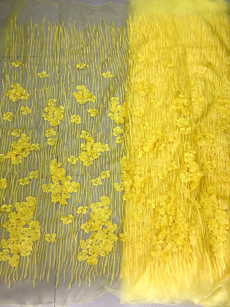 May include: Yellow floral lace fabric with a textured design. The lace has a delicate, floral pattern and is perfect for adding a touch of elegance to any project.