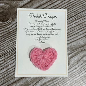 May include: A pink crocheted heart attached to a card with a pocket prayer written on it. The prayer reads: "Heavenly Father, Thank you for looking beyond my faults and for loving me unconditionally. Forgive me when I fail to love others in the same way. Give me eyes to see the needs of the difficult people in my life, and show me how to meet those needs in a way that pleases you. In Jesus Name. Amen."