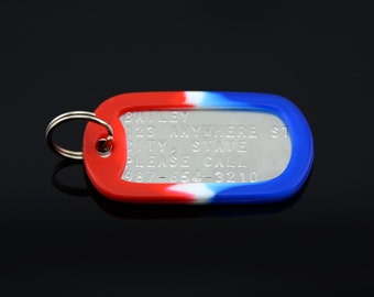 May include: Red, white, and blue dog tag with a silver metal insert. The tag has the text "BAILEY 123 ANYWHERE ST CITY STATE PLEASE CALL 987-654-3210" engraved on it.