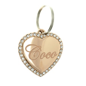 May include: Rose gold heart-shaped pet tag with a clear crystal border and the name "Coco" engraved on the front.