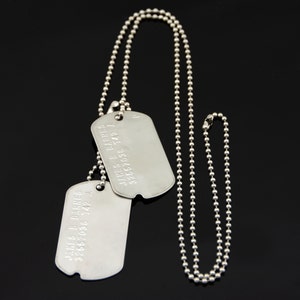 May include: Two silver dog tags on a silver ball chain necklace. The dog tags are engraved with the text "JAMES B. FARES 3265709 742 A".