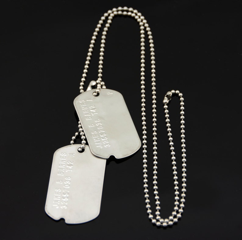 May include: Two silver dog tags on a silver ball chain necklace. The dog tags are engraved with the text "JAMES B. FARES 3265709 742 A".