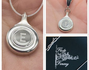 Engraved Silver Flute Key Necklace with Block Letter Script hanging on matching silver snake chain.