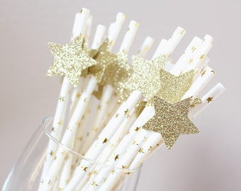 Könnte beinhalten: Ein Bündel weißer Papierstrohhalme mit goldenen Sternen bedruckt. Jeder Strohhalm hat einen goldenen Glitzerstern oben drauf.