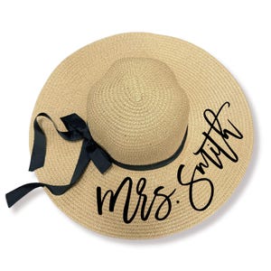 May include: A straw sun hat with a black ribbon and the text "Mrs. Smith" written in black cursive.
