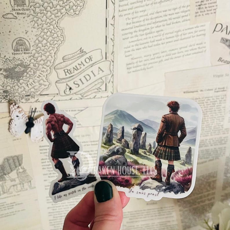 K&ouml;nnte beinhalten: Zwei Aufkleber mit Illustrationen von M&auml;nnern in Kilts. Der erste Aufkleber zeigt einen Mann mit dem R&uuml;cken zum Betrachter, der auf einem felsigen Vorsprung steht. Der Text "I like my scotch on the rocks" befindet sich unter ihm. Der zweite Aufkleber zeigt einen Mann, der vor einer Reihe von Steinen steht, mit dem Text "Je suis pr&ecirc;t!" darunter.