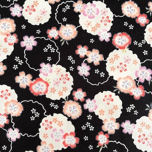 May include: Black fabric with a repeating floral pattern. The design features clusters of white, pink, and peach-colored cherry blossoms, outlined with white, on a black background. Small white star-shaped accents are scattered throughout.