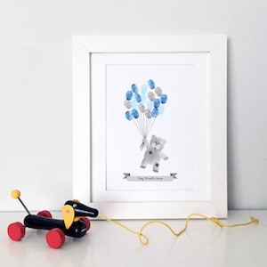 Peut inclure: Une impression encadrée avec un ours en peluche gris tenant des ballons bleus et gris. Le texte "Baby Michael's Shower" est imprimé sur une bannière sous l'ours.