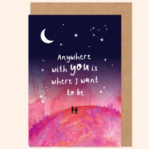 May include: A romantic greeting card with a watercolour design. The card shows a dark blue sky with a crescent moon, stars, and constellations. The text reads "Anywhere with you is where I want to be." Two small figures stand on a pink and purple hill.