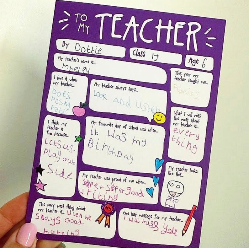 May include: A purple handmade card with the words "TO MY TEACHER" at the top. The card includes handwritten text and drawings, with sections for the teacher's name, age, and favorite things. The card is held by a person.