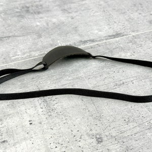 May include: A black leather eye patch with an adjustable strap. The patch is designed to cover one eye.