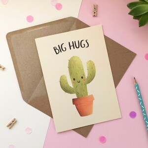 May include: A greeting card featuring a cartoon cactus in a pot. The cactus is green and has a smiling face. The text on the card reads "BIG HUGS".