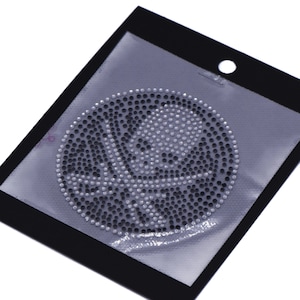 May include: A round, black and white rhinestone iron-on patch with a swirl design.