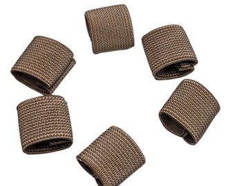 May include: Six brown elastic bands, each with a woven texture, are scattered on a white background.