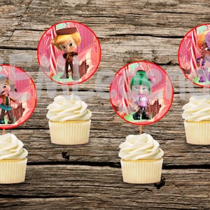 May include: Five cupcake toppers featuring characters from the animated series, 'The Loud House'. Each topper is a circle with a red border and a pink background. The characters are depicted in a cartoon style and are standing in a candy-themed forest setting.