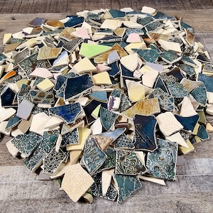 May include: A large pile of broken ceramic tiles in various colors and patterns, including green, brown, yellow, and white.