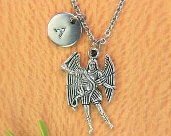 May include: Silver necklace with a charm of an angel with wings and a round charm with the letter A.