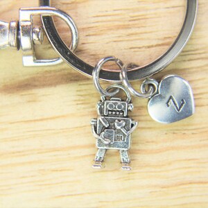 May include: Silver robot keychain with a heart charm that has the letter Z on it.