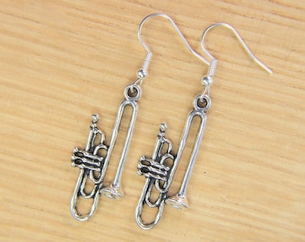 May include: A pair of silver trumpet-shaped dangle earrings. The earrings have a silver hook closure.