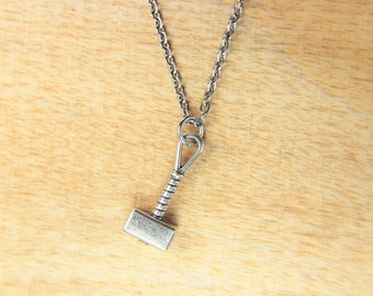 May include: A silver necklace with a small silver hammer pendant.