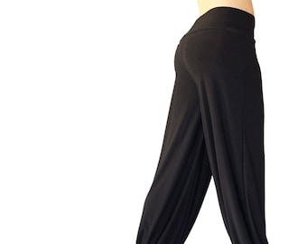 May include: Black, loose-fitting pants with a wide leg and elastic waistband.
