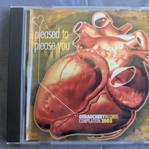 Pode incluir: Uma caixa de CD com uma ilustração detalhada de um coração humano em tons de vermelho e castanho. O texto "pleased to please you" é exibido em branco, juntamente com "DEBAUCHERY RECORDS COMPILATION 2005". A caixa está numa manga de plástico transparente.