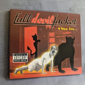 Könnte beinhalten: CD-Albumcover für "Full Devil Jacket" mit rotem und braunem Hintergrund. Das Cover zeigt den Namen der Band in einer stilisierten Schriftart, ein krabbelndes Kind und teuflische Silhouetten. Das Cover hat auch einen Hinweis für Eltern.