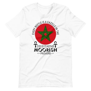 May include: White t-shirt with a red circle and green star, with the text "Every beetle is a gazelle in the eyes of its mother Moorish ***Proverb***"