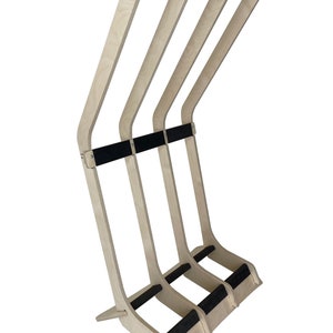 Puede incluir: Un soporte para tablas de surf de madera con tres ranuras para guardar tablas de surf. El soporte est&aacute; hecho de madera clara con almohadillas de goma negra en los brazos y la base.
