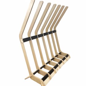 Puede incluir: Un soporte para tablas de surf de madera con seis ranuras para guardar tablas de surf. El soporte est&aacute; hecho de madera de color claro y tiene almohadillas de goma negras en los brazos para proteger las tablas.