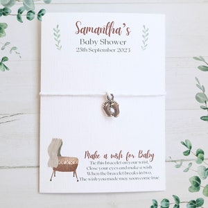 May include: White string bracelet with a silver baby feet charm and a card that says "Samantha's Baby Shower 25th September 2023" and "Make a wish for Baby Tie this bracelet on your wrist, Close your eyes and make a wish When the bracelet breaks in two, The wish you made may soon come true"