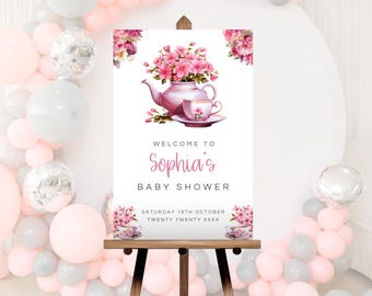 Może przedstawiać: Witamy znak na baby shower na drewnianym sztaludze. Znak przedstawia różowy czajniczek i filiżankę z kompozycjami kwiatowymi. Tekst brzmi "Witamy na baby shower Sophii" z datą poniżej. Różowe i szare balony otaczają znak.