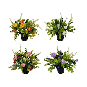 May include: Four artificial floral arrangements in black pots. Each arrangement features a different colour scheme: yellow and orange, white, pink and red, and purple. Green foliage and white accents complete the designs.