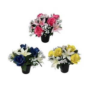 May include: Three artificial flower arrangements in black pots. One arrangement features pink roses and lilies, another has blue roses and white lilies, and the third has yellow roses and white lilies. All arrangements include small white filler flowers.