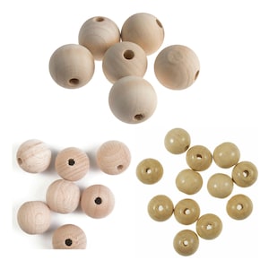 May include: A collection of wooden beads in two sizes. The larger beads are natural wood colour and the smaller beads are a light beige colour.