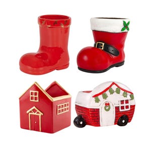 May include: Four festive ceramic containers. Includes a red boot, a Santa boot with a black buckle, a red house with gold trim, and a red and white camper with a wreath and Christmas trees.