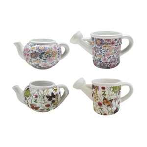 May include: Four ceramic garden-themed items: two teapots and two watering cans. The teapots and watering cans are white with floral and butterfly patterns in various colours. The teapots have a handle and spout. The watering cans have a handle and a spout.
