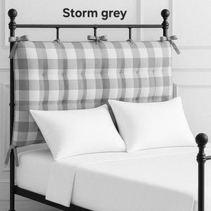 May include: A bed with a black metal frame, white bedding, and two white pillows. The headboard features a gray and white checkered pattern with the text "Storm grey" at the top.