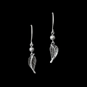 May include: A pair of silver earrings with a leaf design and a small bead accent.