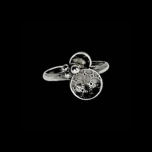 May include: A silver ring with a textured circular design and three small silver beads.