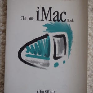 May include: The cover of a book titled "The Little iMac Book" by Robin Williams. The cover features a stylized illustration of an iMac in teal, gray, and black.