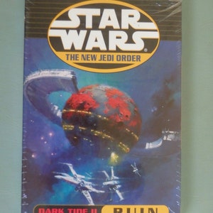 May include: A Star Wars book cover featuring a red planet with a space station orbiting it. The title is "Dark Tide II: Ruin" by Michael A. Stackpole. The book is part of the New Jedi Order series.