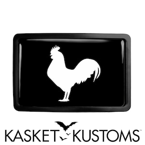 May include: Black and white rooster silhouette on a black background. The rooster is facing right and has a large comb and wattles. The image is in a rectangular frame.