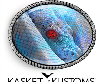 Peut inclure: Une boucle de ceinture en argent avec un serpent bleu à l'œil rouge. Le serpent est enroulé et sa tête est tournée vers le spectateur. La boucle est de forme ovale et a une bordure texturée.