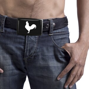 May include: A black leather belt with a silver buckle featuring a white rooster silhouette.