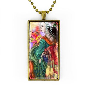 May include: A rectangular pendant necklace with a bronze-colored frame. The pendant features a colorful illustration of a woman in a traditional Japanese kimono. The woman has dark hair and is adorned with flowers. The background has a mix of colors.