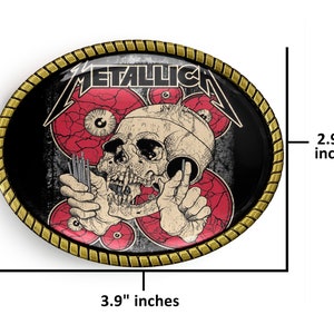 Puede incluir: Una hebilla de cintur&oacute;n de metal de color dorado con un dise&ntilde;o negro y rojo. El dise&ntilde;o presenta una calavera con ojos y la palabra "Metallica" en letras blancas. La hebilla mide 3,9 pulgadas de ancho y 2,9 pulgadas de alto.