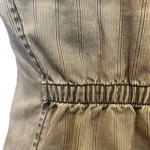 May include: A close-up of a brown and white striped fabric with a black elastic band at the waist.