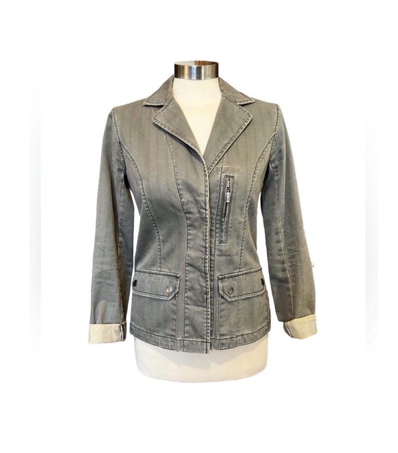 May include: A gray denim jacket with a zipper closure and two flap pockets. The jacket has a collar and long sleeves.